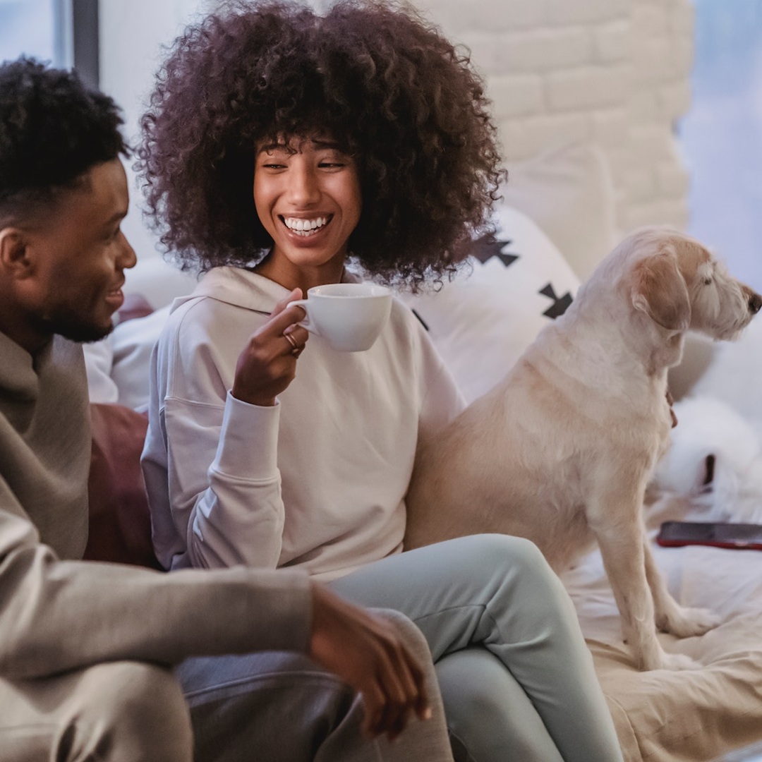 Family standing in front of their home with their dog